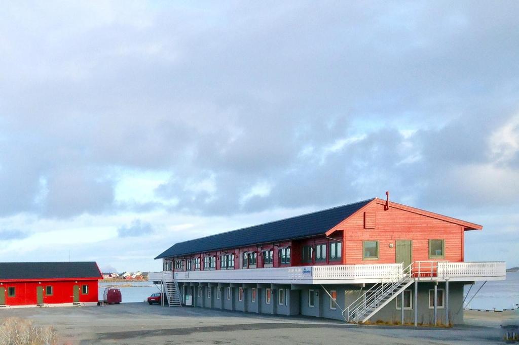 un edificio rojo con techo negro en Kaikanten Rorbuer - Røst, en Røst