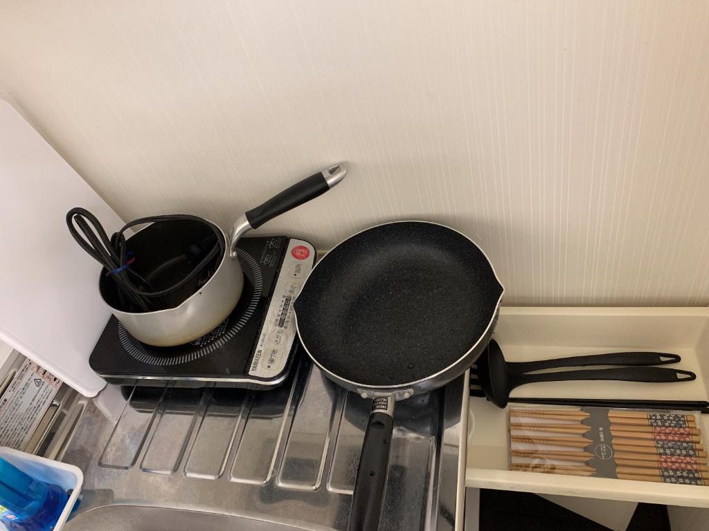 a frying pan and a pot on top of a stove at ACT Residence No.1 in Tokyo