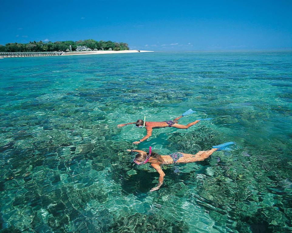 two people laying in the water in the ocean at Sea-lily Beach Villa in Belle Mare