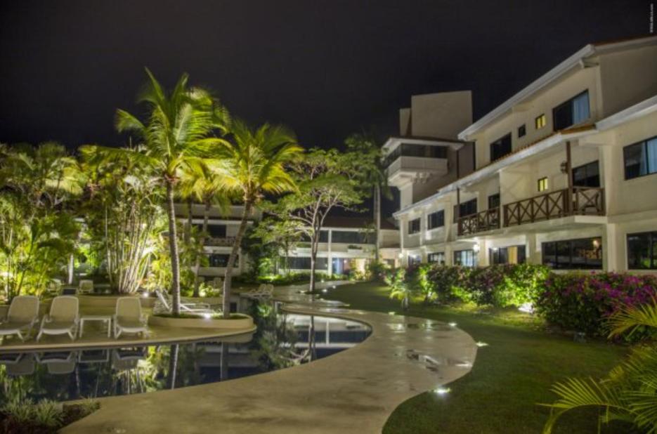 a hotel courtyard with chairs and a pool at night at Private family room in Coronado Luxury Club & Suites in Playa Coronado