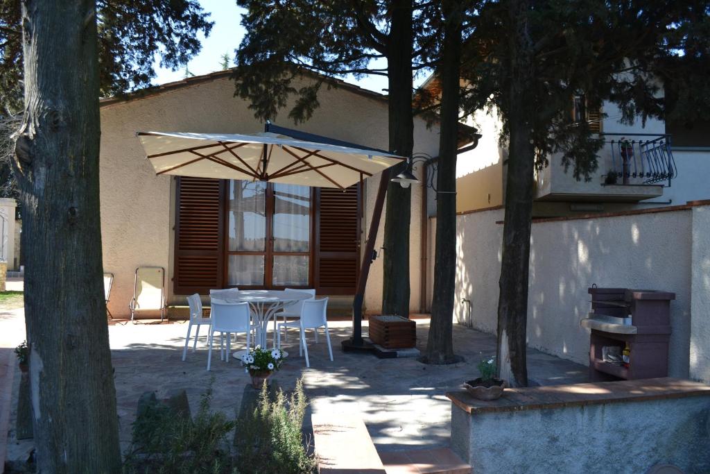 un patio con mesa y sombrilla en Charming Self House, en San Casciano in Val di Pesa