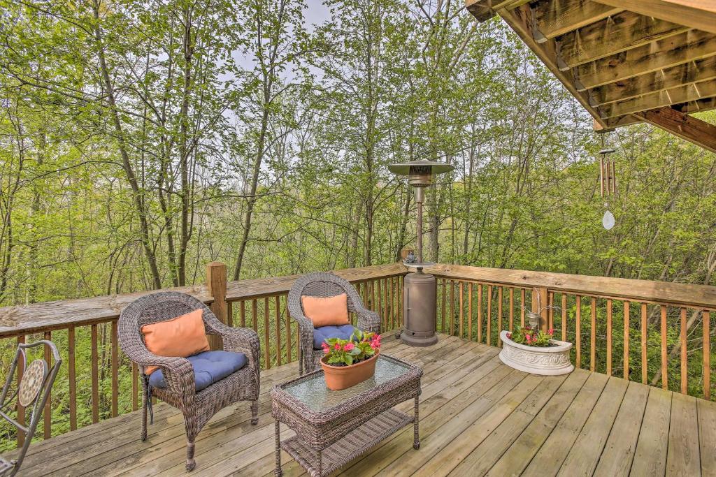 2 chaises et une table sur une terrasse en bois dans l'établissement Resort Cabin with Fire Pit Golf, Hike and Play!, à Rothbury