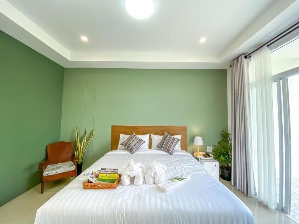 Un dormitorio con una gran cama blanca y una ventana en น่านวรรณวัตร รีสอร์ท Nan Wannawat Resort, en Ban Tong