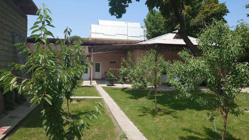 une cour avec des arbres devant une maison dans l'établissement MEGI, à Ferghana