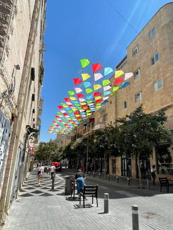 a row of colorful kites flying in the air at La Perle Hotel in Jerusalem