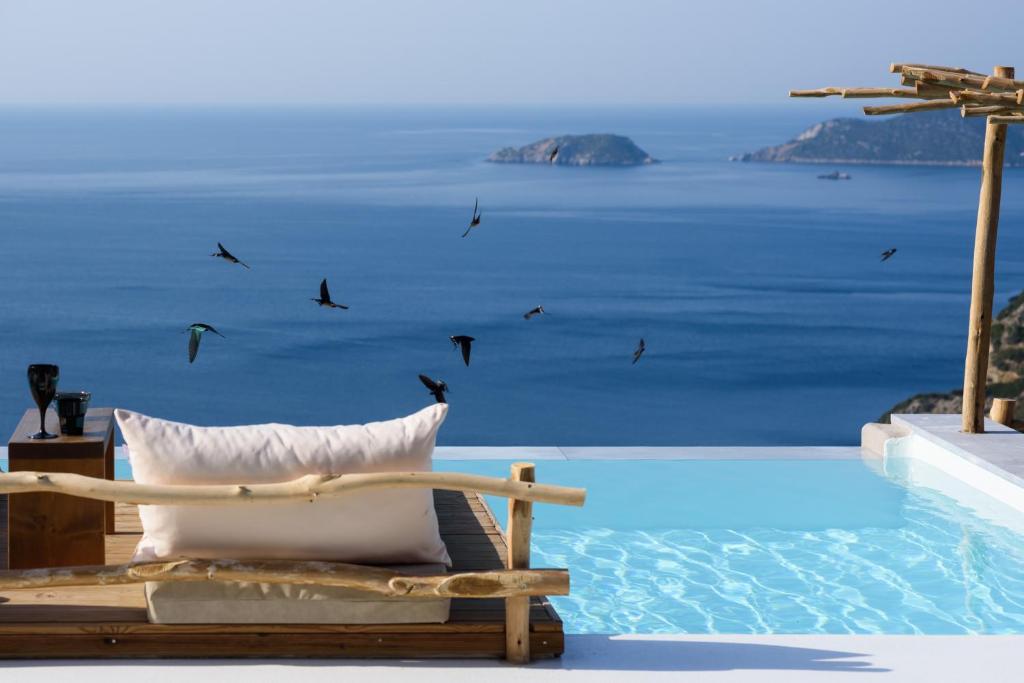 a chair next to a pool with a view of the ocean at ALETRI new swim up HOTEL in Alonnisos