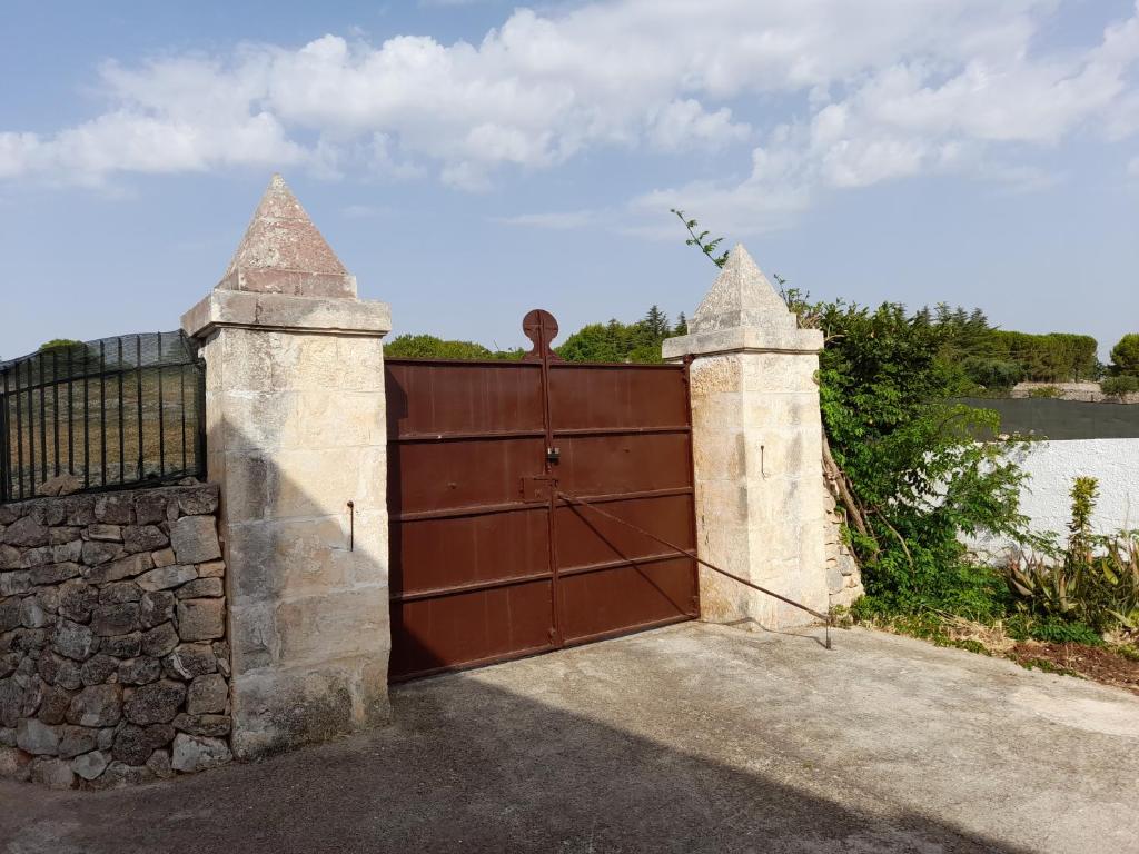 een grote houten poort met een stenen muur bij Villa Ottocento Molillo in Ostuni