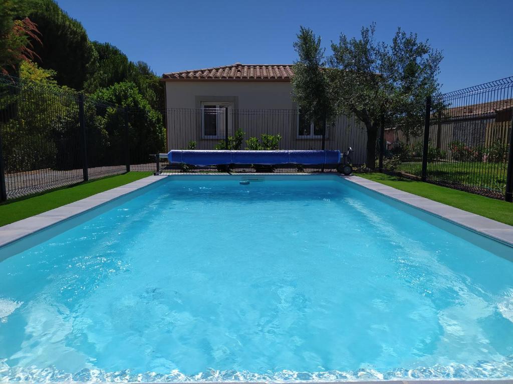 a large blue swimming pool in front of a house at Le Logis de Liliana in Villemoustaussou
