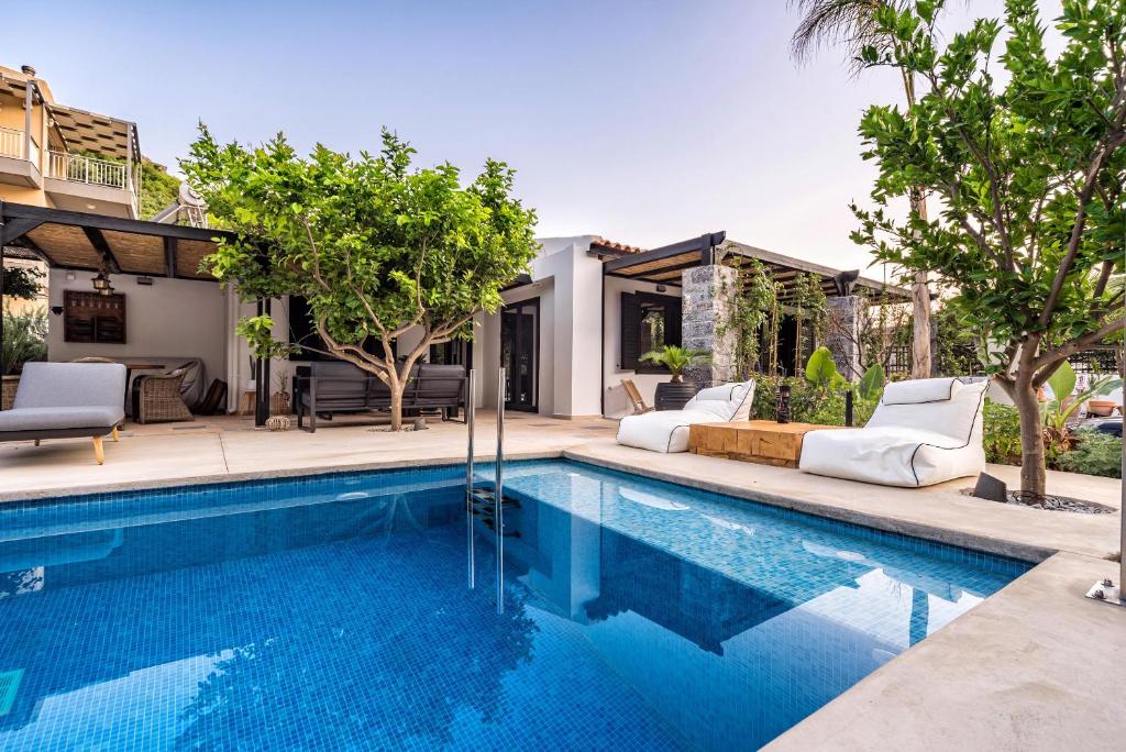 uma piscina com duas espreguiçadeiras ao lado de uma casa em HALO Ligaria Suite 100m next to the beach with private pool em Lygaria