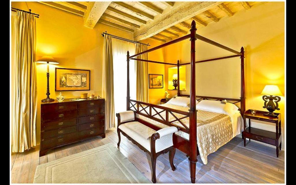 la locanda di anita في شيتونا: غرفة نوم مع سرير بأربعة أعمدة ومكتب