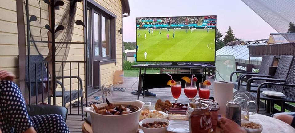 una mesa con comida y un partido de fútbol en una pantalla en Voodikoht Viljandis en Viljandi