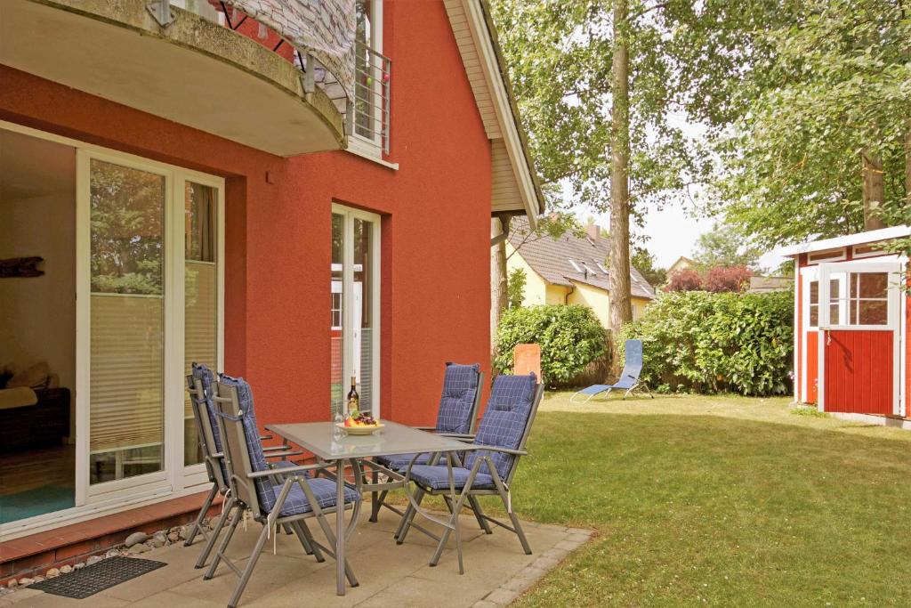 eine Terrasse mit einem Tisch und Stühlen vor einem Haus in der Unterkunft Ferienwohnung Möwennest mit Terrasse in Middelhagen