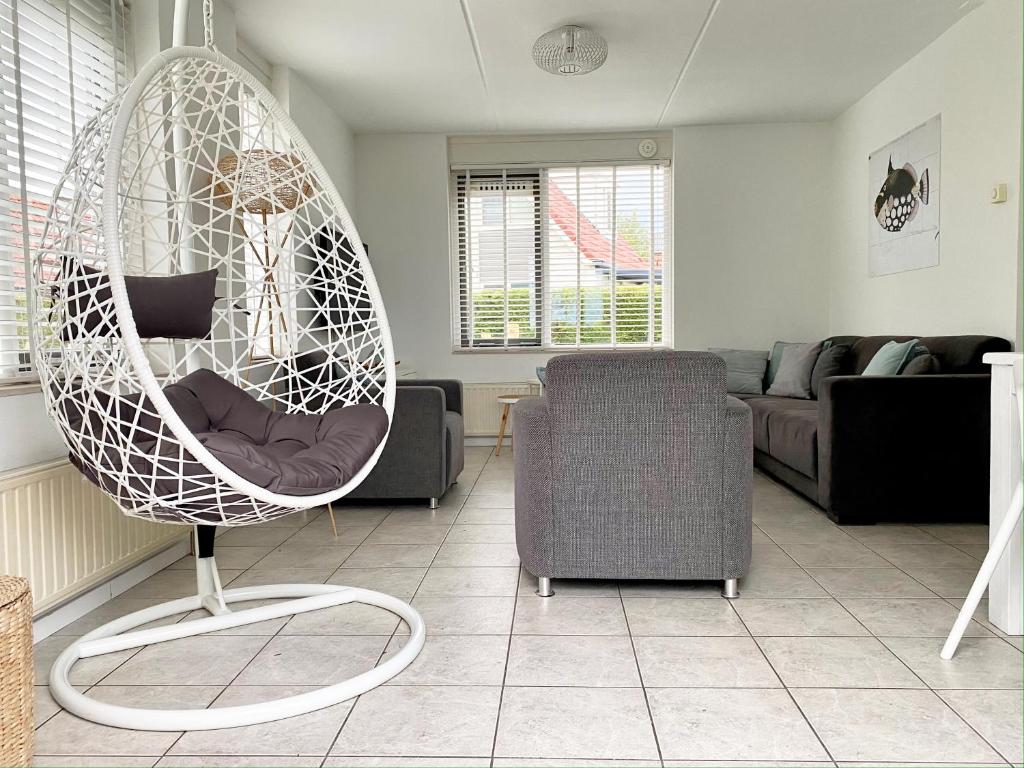 ein Wohnzimmer mit einem Schaukelstuhl und einem Sofa in der Unterkunft Hello Zeeland - Vakantiehuis Stern 218 in Breskens