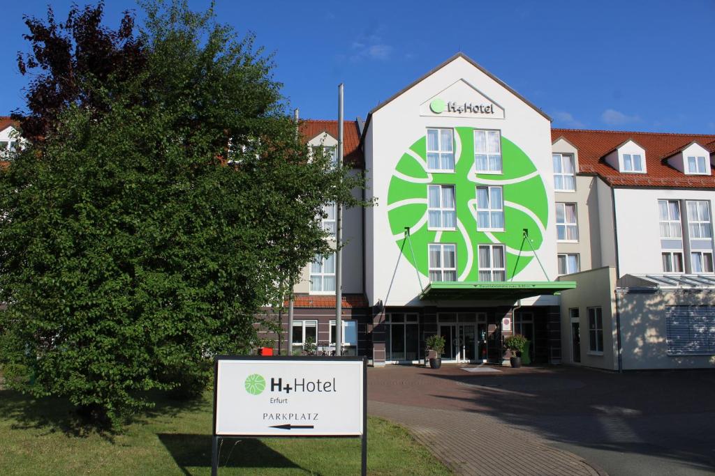 a large building with a sign on the front of it at H+ Hotel Erfurt in Erfurt