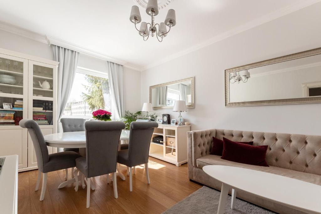 uma sala de estar com uma mesa e cadeiras e um sofá em Elegant near Old Town - free parking em Gdansk