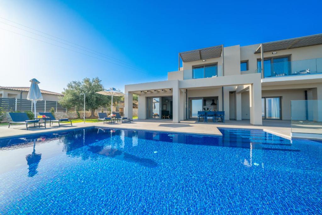 een zwembad voor een huis bij villa Shades of blue in Trapezaki