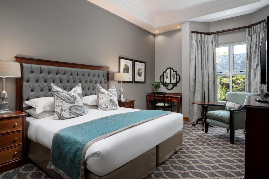 a hotel room with a large bed and a chair at Premier Hotel Quatermain in Johannesburg