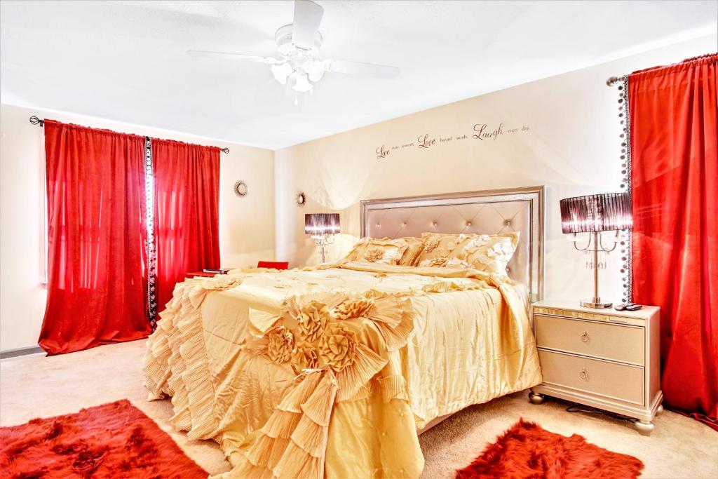 a bedroom with a large bed with red curtains at Sweet Home Georgia - Entire 3 bedroom Luxury in Duluth