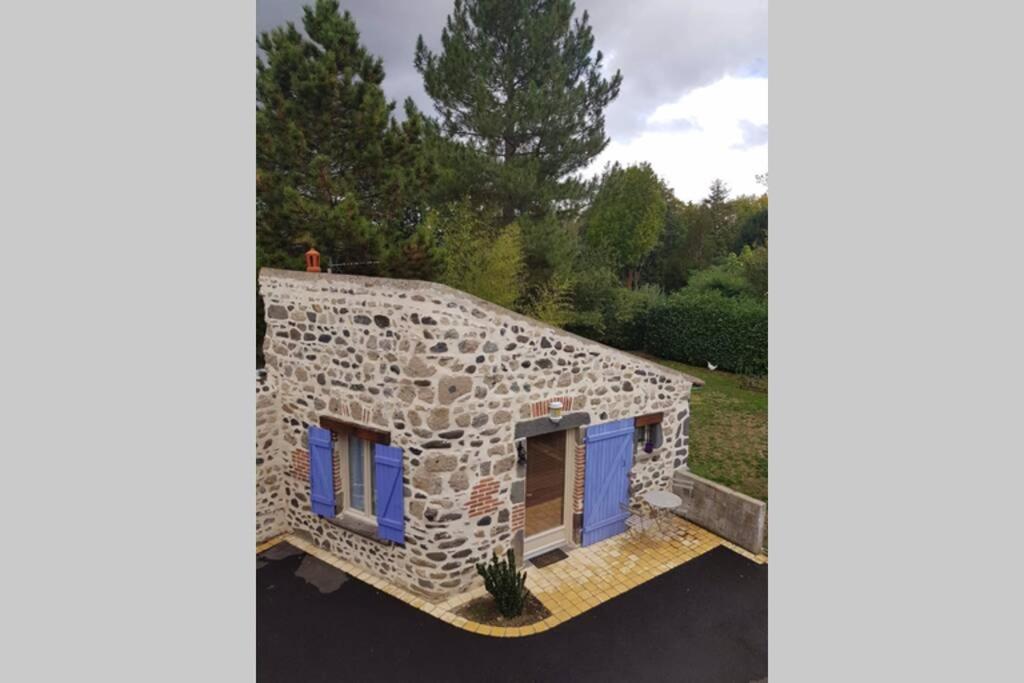 Casa de piedra grande con puertas azules y patio en Maisonnette en pierre indépendante de 20 m2 en Saint-Cirgues-sur-Couze