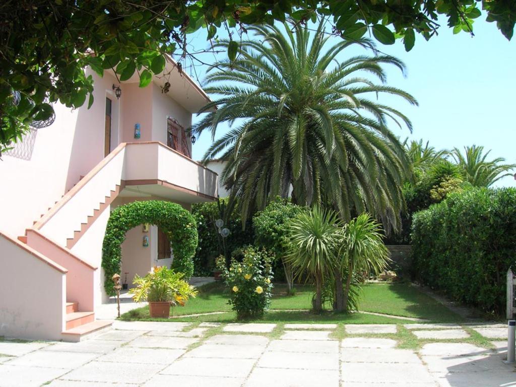 uma casa com uma palmeira no quintal em Casa vacanza Sa Ferula em Flumini di Quartu