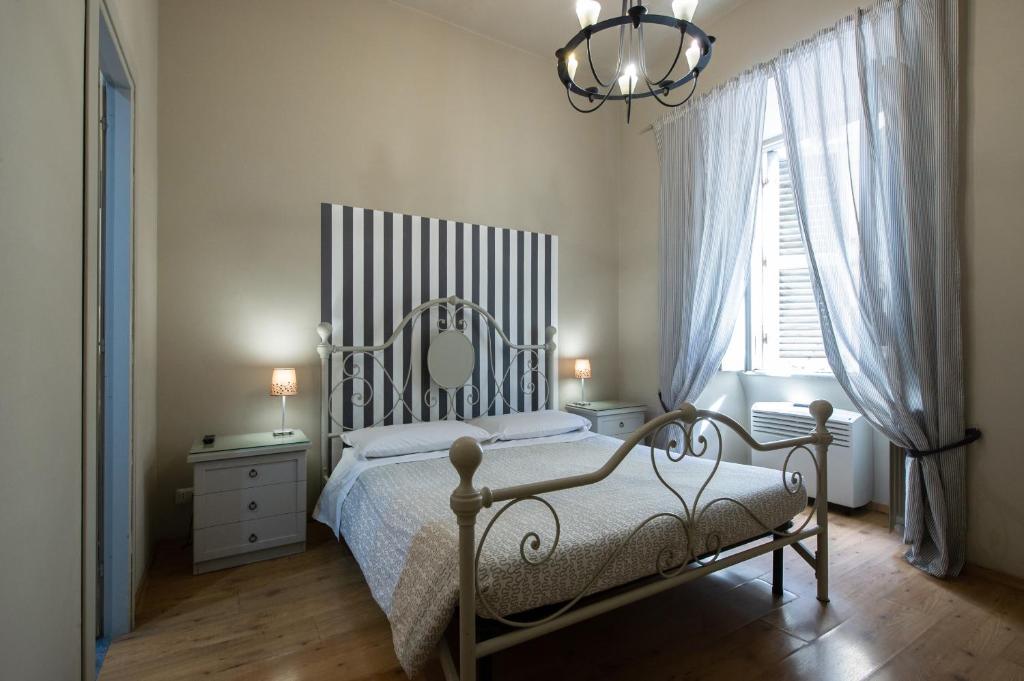 a bedroom with a bed and a window and a chandelier at Vaticana Residenza Ottaviani in Rome