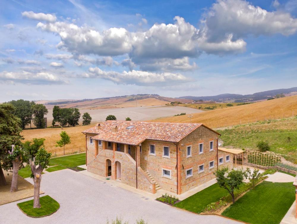 an aerial view of a large brick house in a field at Podere Gonzaga in Pienza