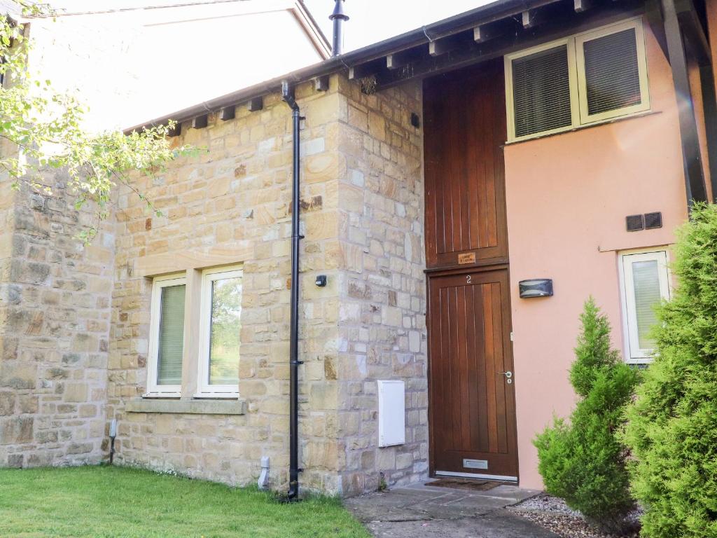 a brick house with a wooden door at Lark Meadow in Carnforth