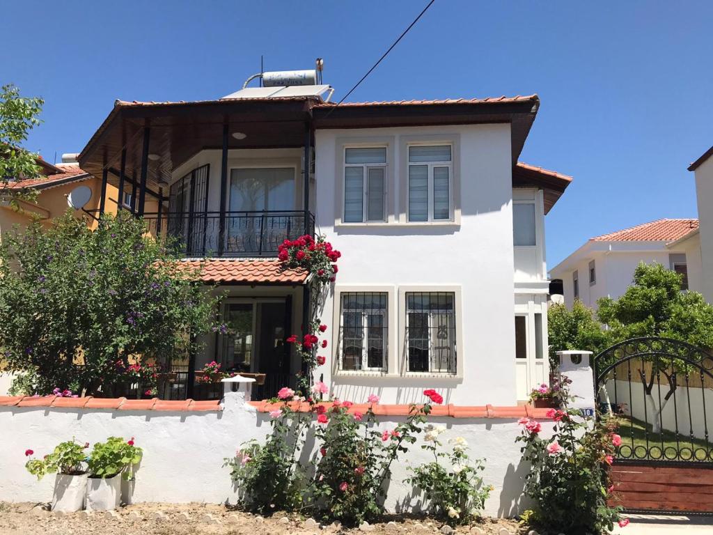 uma casa branca com flores à frente em Villa Günay em Ortaca