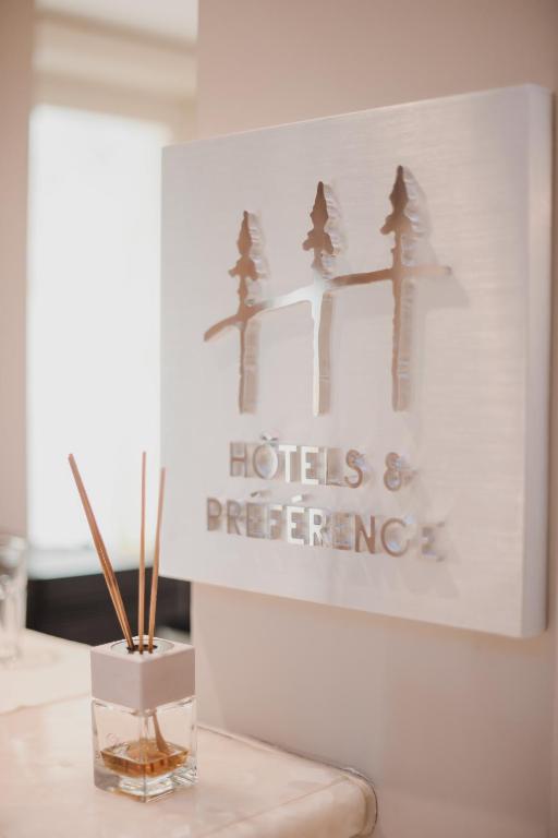 a vase on a table with a sign on a wall at Lot Boutique Hotel by Hotels and Preference in Tirana