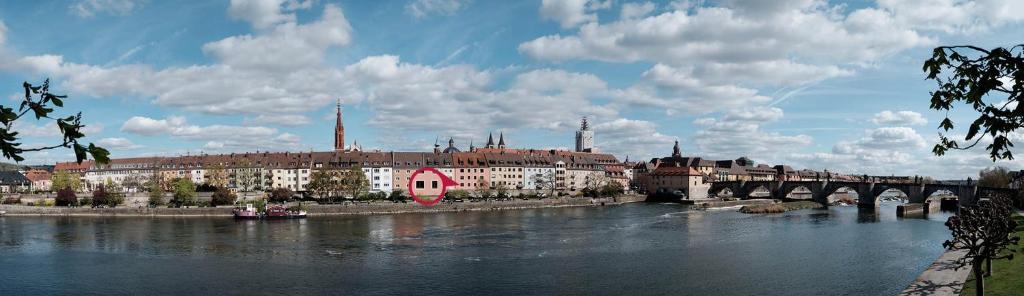 uma cidade com uma ponte sobre um rio com um barco em FeWo Alte Mainbrücke em Wurtzburgo