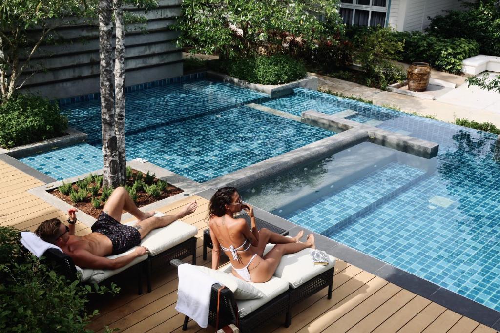 um grupo de pessoas deitadas em cadeiras junto a uma piscina em Na Sook Wellness Resort em Ao Nam Mao
