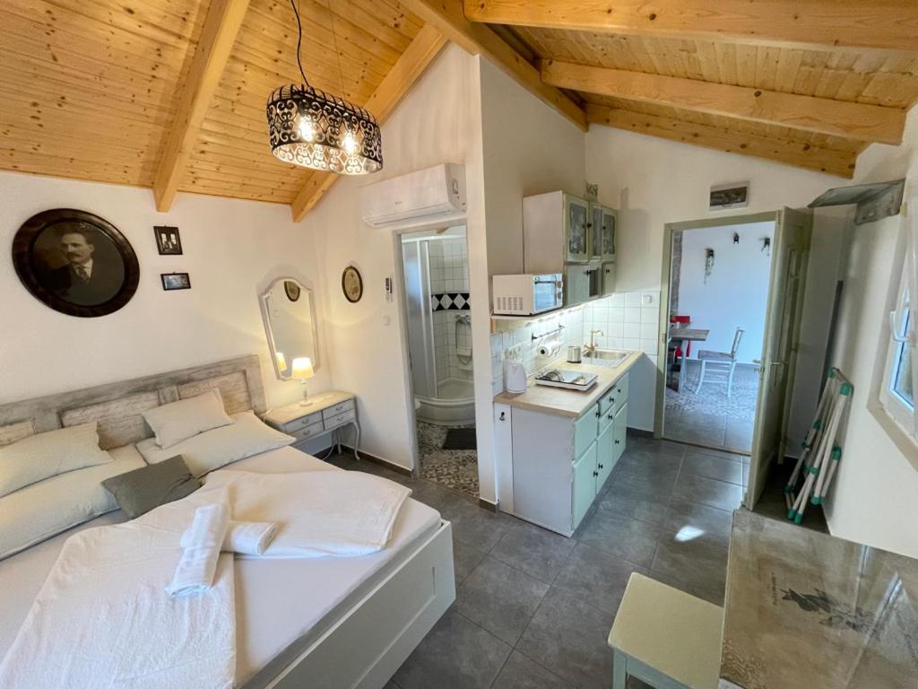 a bedroom with a white bed and a bathroom at Ibolya Apartman in Csisztapuszta