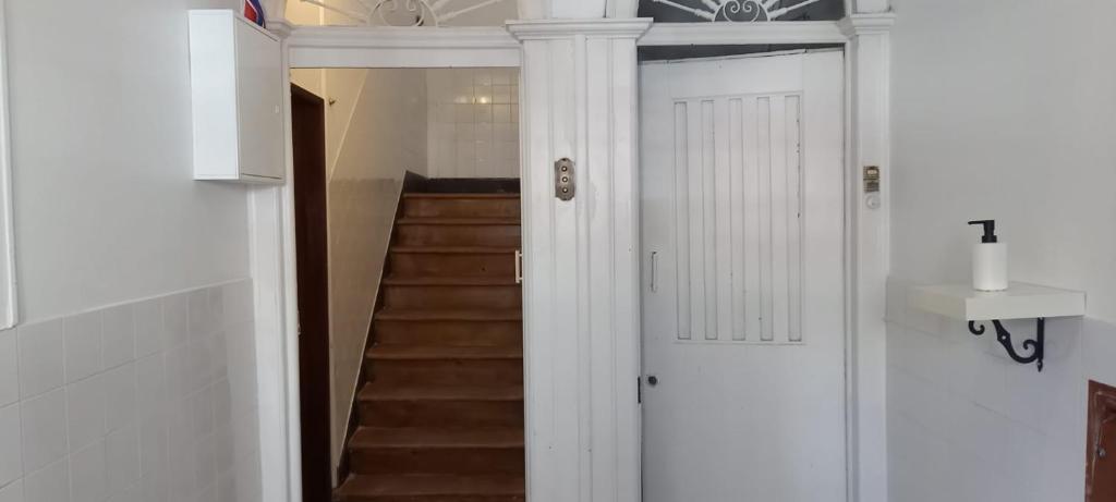 un pasillo con una puerta blanca y una escalera en Amoreiras Studios en Lisboa