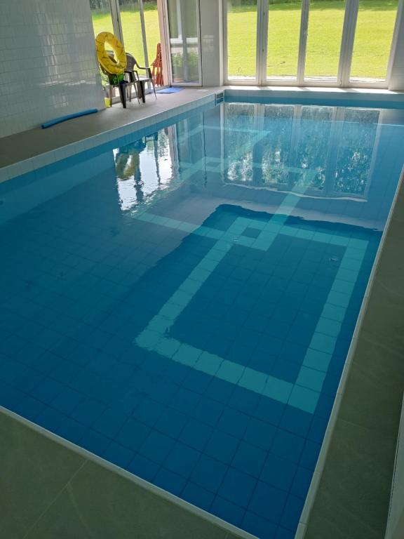 a swimming pool with a blue tile floor at Siedlisko Błotnia in Mierzeszyn