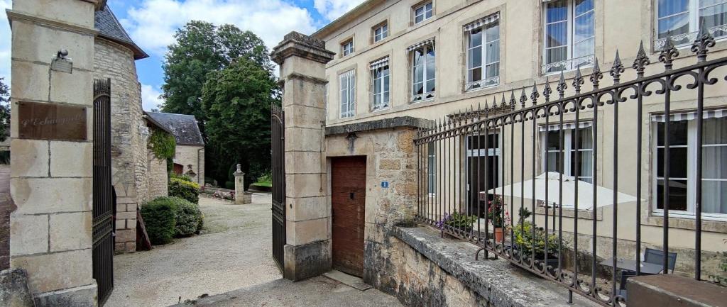 un antiguo edificio de piedra con una puerta y una puerta en Manoir de L'Echauguette, en Laignes