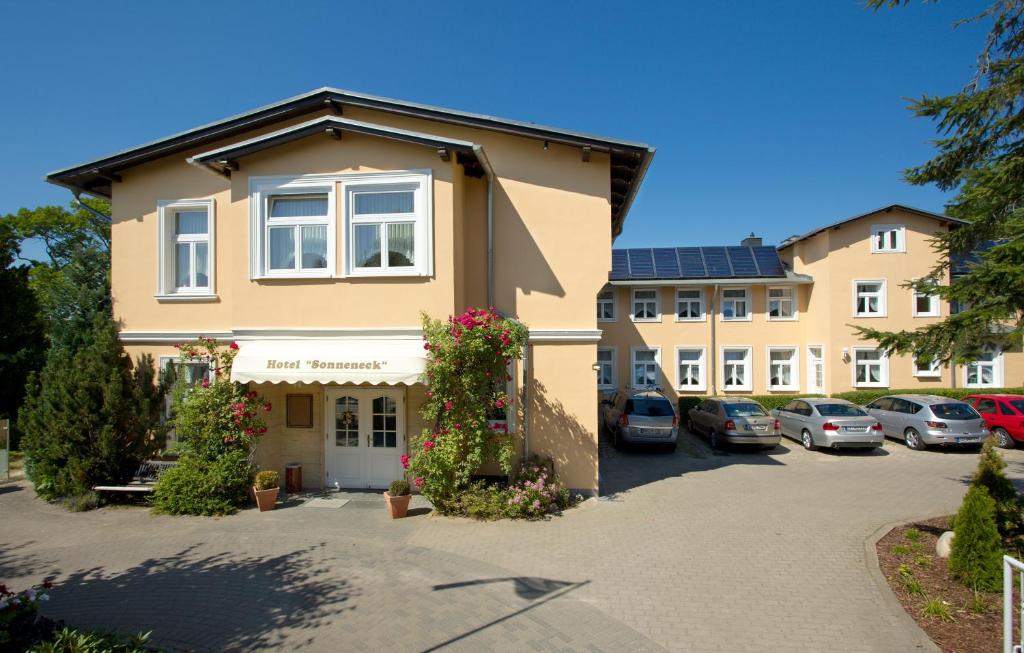 ein Gebäude mit Autos auf einem Parkplatz in der Unterkunft Hotel Sonneneck in Zinnowitz