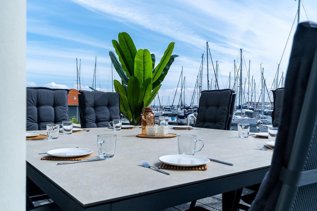 una mesa con platos y vasos en la parte superior de un puerto deportivo en Appartement in Zeeland - Kabbelaarsbank 2C - Port Marina Zélande - Ouddorp - not for companies, en Ouddorp