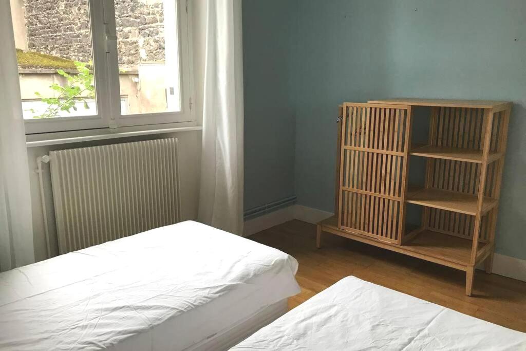 a room with two beds and a window and a book shelf at La Maison Blatin in Clermont-Ferrand