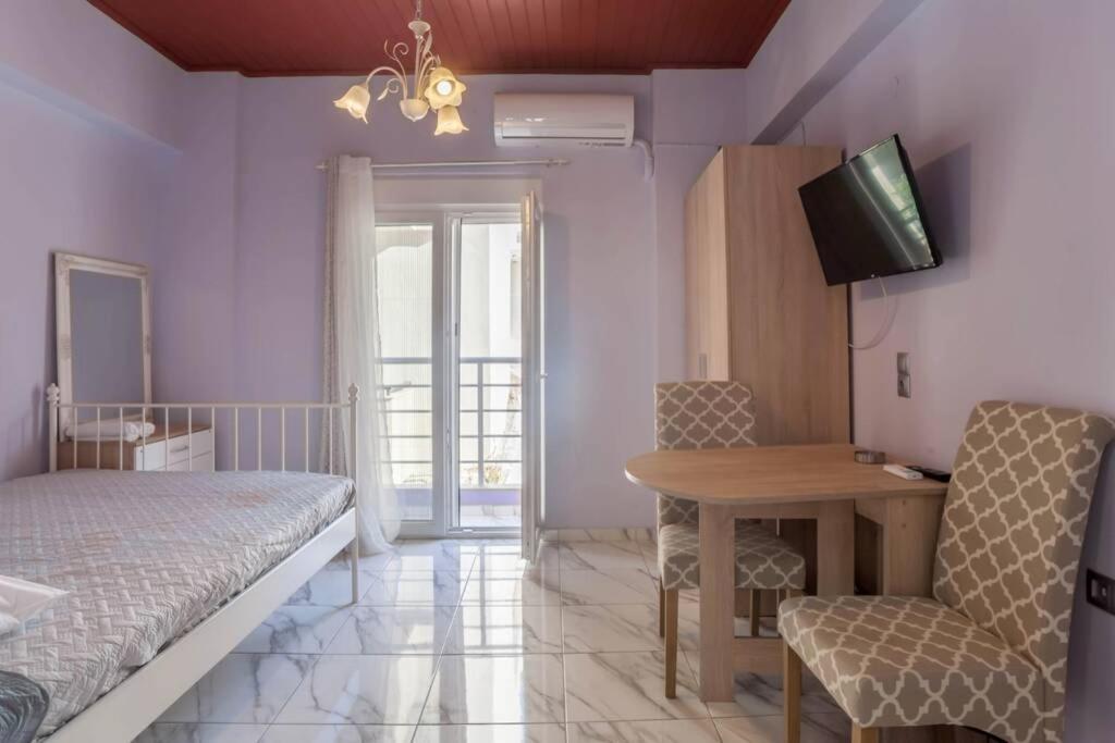 a bedroom with a bed and a table and a chair at Faidra 02 City Center in Heraklio