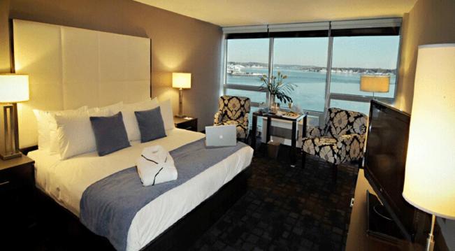 Habitación de hotel con cama y vistas al océano en Oyster Point Hotel en Red Bank