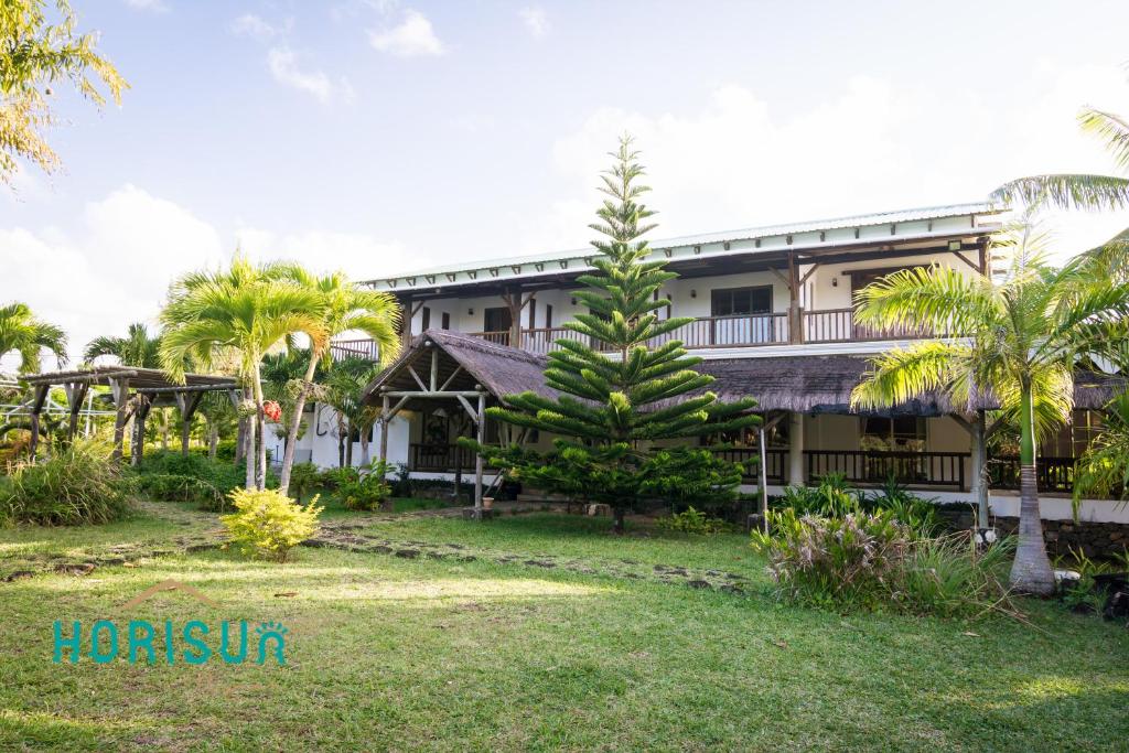 a house with a palm tree in front of it at Horisun in Belle Mare