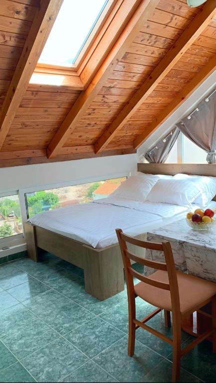 a bedroom with a bed and a table with a chair at Laura Studio Apartman in Mlini