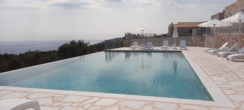 a large swimming pool with a balcony overlooking the ocean at Koukouri Village in Kafióna