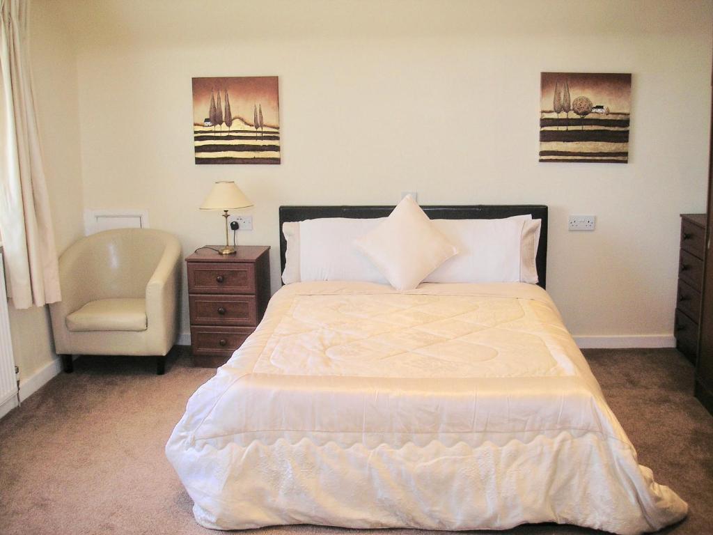 a bedroom with a large bed and a chair at 24 Elmhurst Road in Lytham St Annes