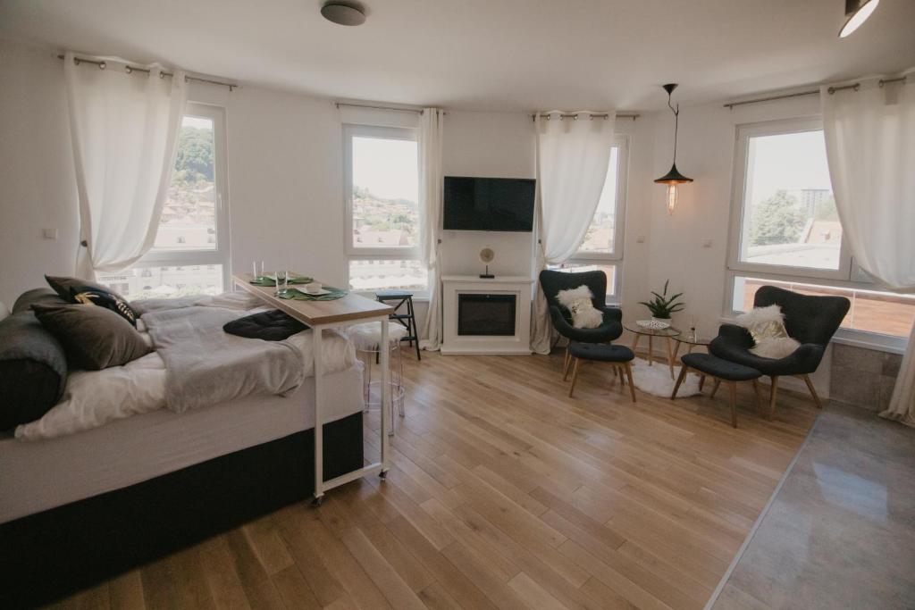 a bedroom with a bed and a table and chairs at Akro Studio apartman in Tuzla