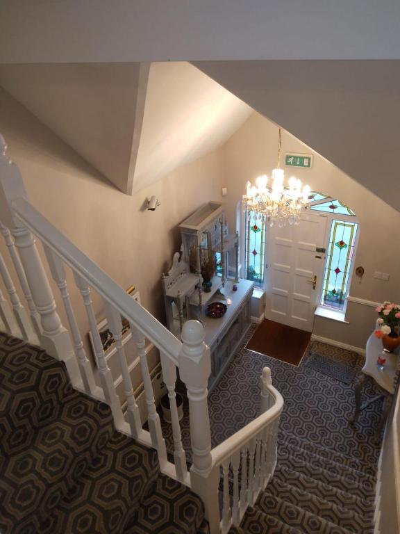 an overhead view of a staircase with a chandelier at Colonelwood House in Westport