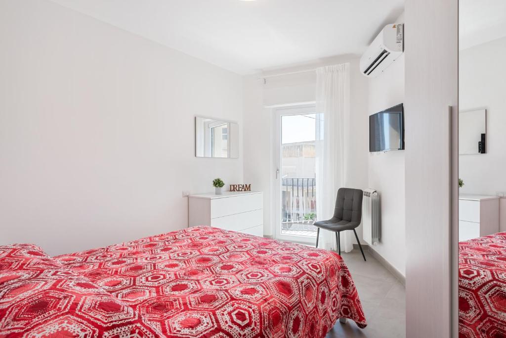 biała sypialnia z czerwonym łóżkiem i krzesłem w obiekcie Cozy Apartment near the Historic Center w Taominie