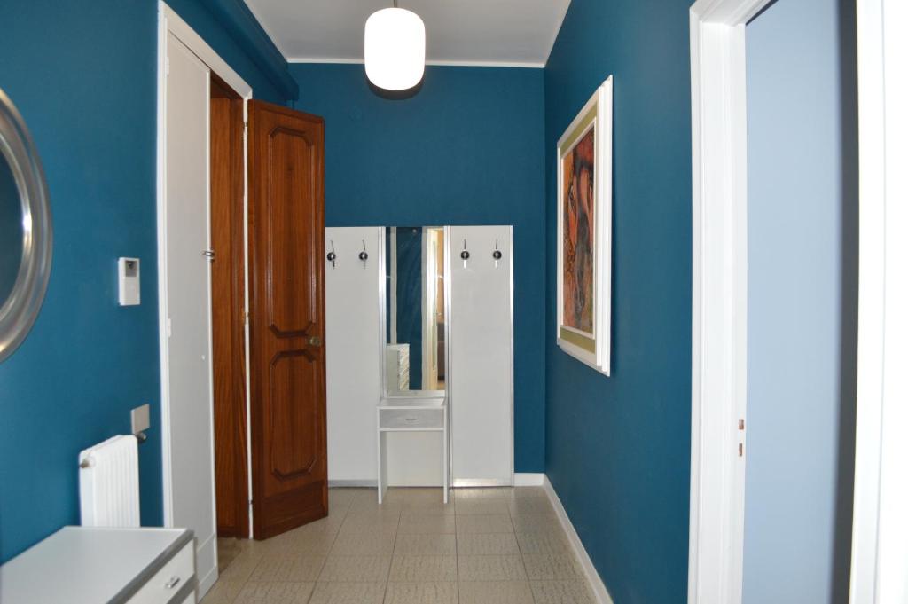 bagno con pareti blu, lavandino e specchio di Gallipoli Apartment ActiveLife a Gallipoli
