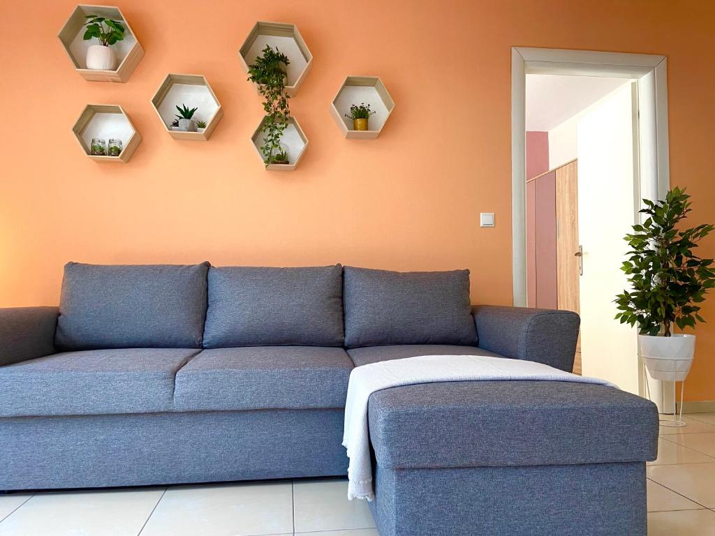 een blauwe bank in een woonkamer met planten aan de muur bij Irini Apartments in Kavala
