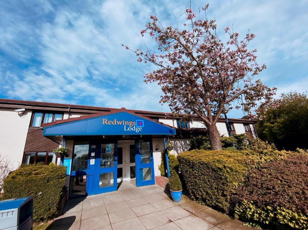 a building with a blue sign that reads readings fuels at Redwings Lodge Baldock in Baldock